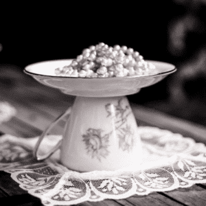 Jabonera curiosa y vintage hecha con taza y plato de porcelana con flores, dandoles una segunda vida, sobre encaje blanco