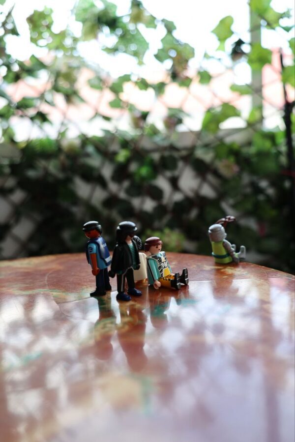 Mesa auxiliar vintage azul de los años 40 con detalles dorados, tapa texturizada verde y escena de muñecos Playmobil-mueble original y decorativo