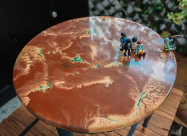 Mesa auxiliar vintage azul de los años 40 con detalles dorados, tapa texturizada verde y escena de muñecos Playmobil-mueble original y decorativo